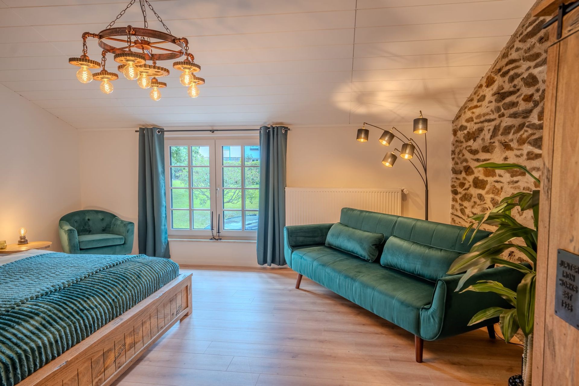Ruhiges Schlafzimmer mit Naturstein-Wand und samtigem Grün