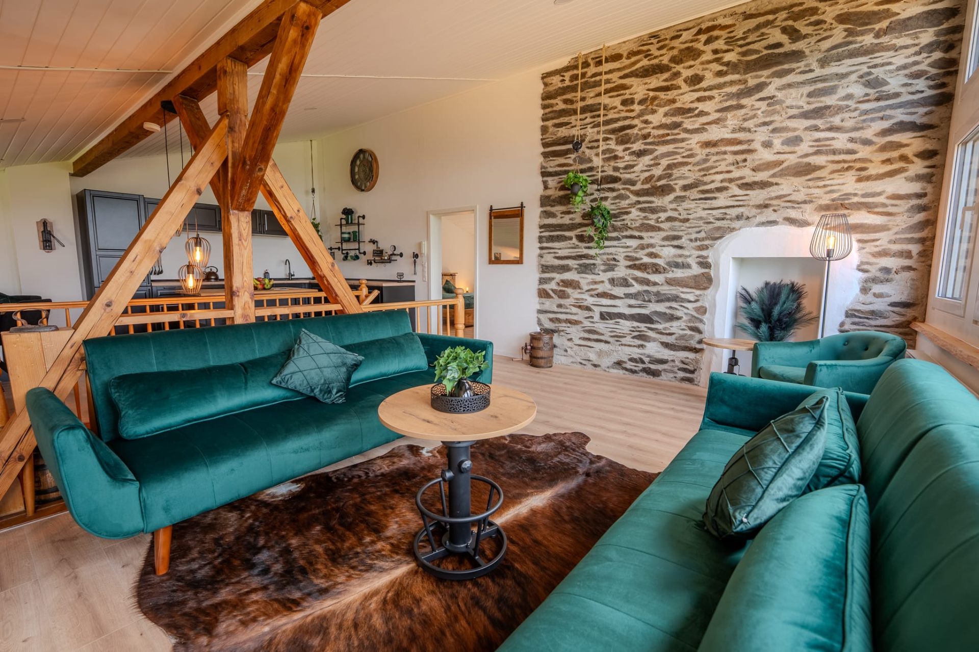Renovierter Wohnbereich mit historischer Natursteinwand und Holzbalken
