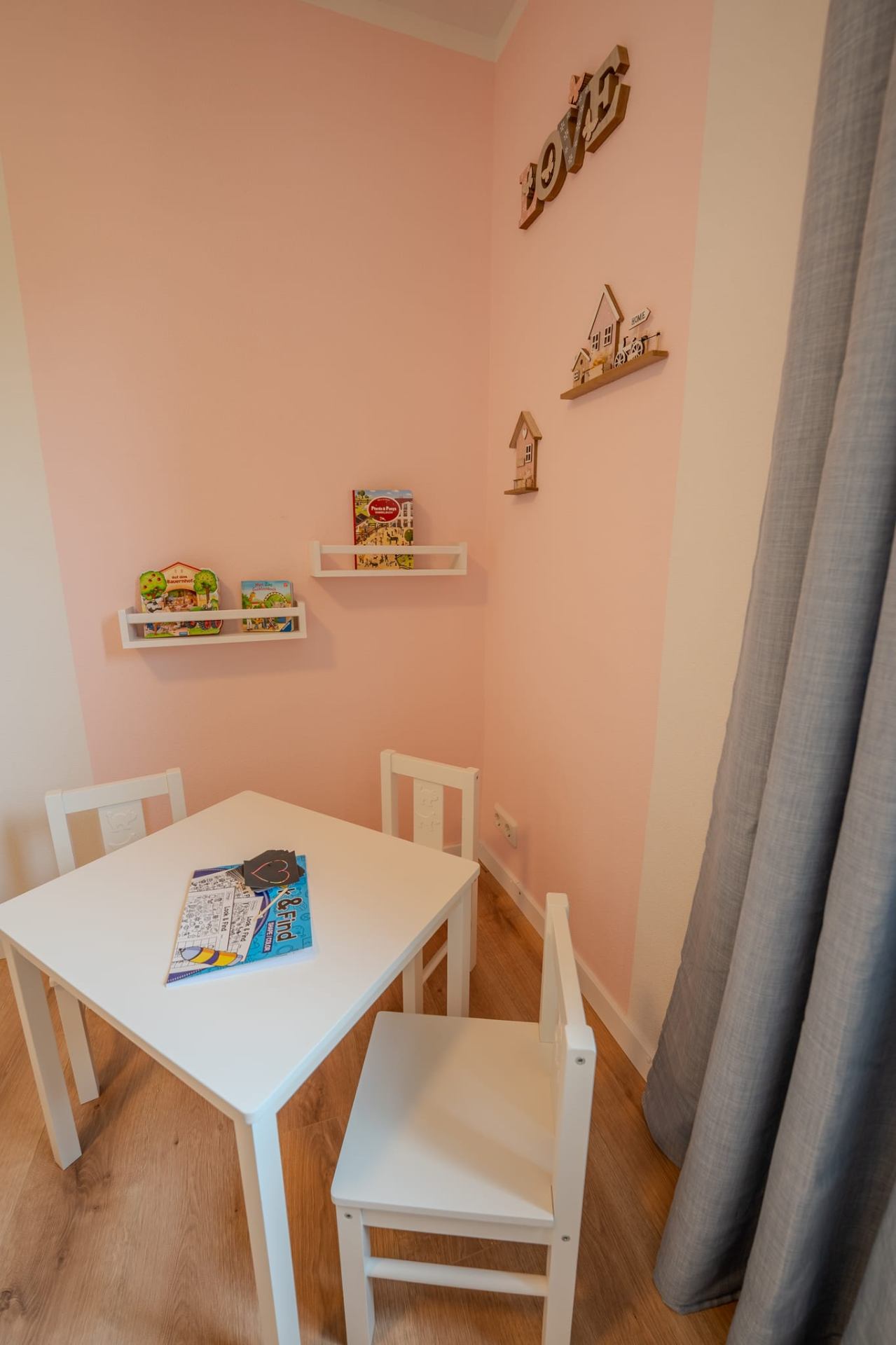 Kinderspielecke mit Maltisch und Kinderbüchern in Rosé